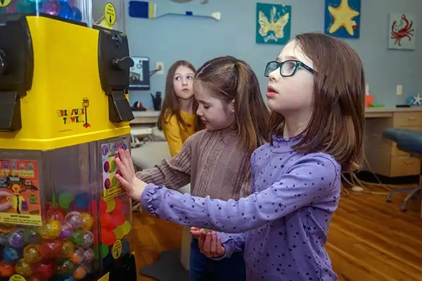 Some young patients playing with the toy vending machine at Jacobsen Pediatric Dentistry 