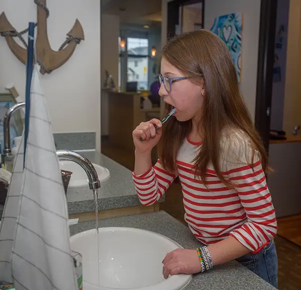 A young girl brushing her teeth at Jacobsen Pediatric Dentistry 