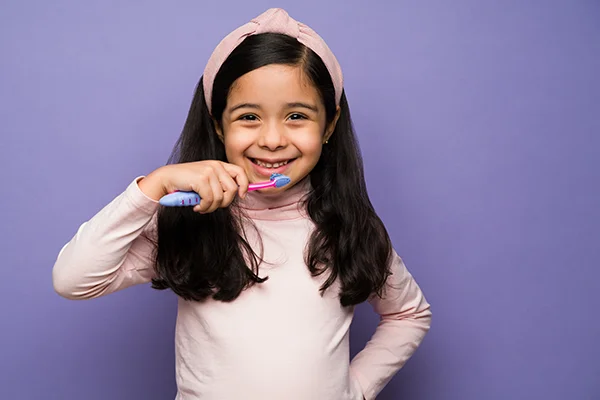 Young girl brushing her teeth enthusiastically