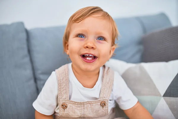 Child with only a few teeth smiling inquisitively at the camera