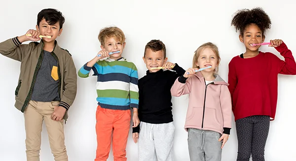 A diverse group of kids brushing their teeth together