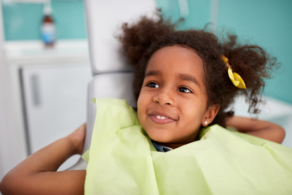 Adorable smiling girl in dental chair