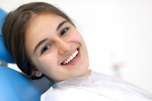 Smiling teenager sitting in dental chair